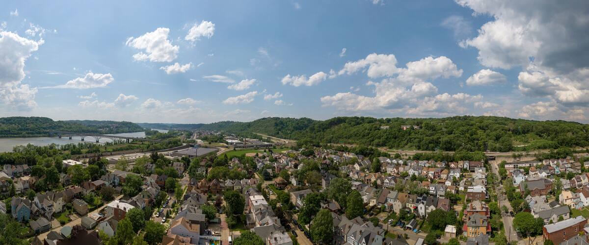 A river, bridge, and residential area with a hilly landscape.