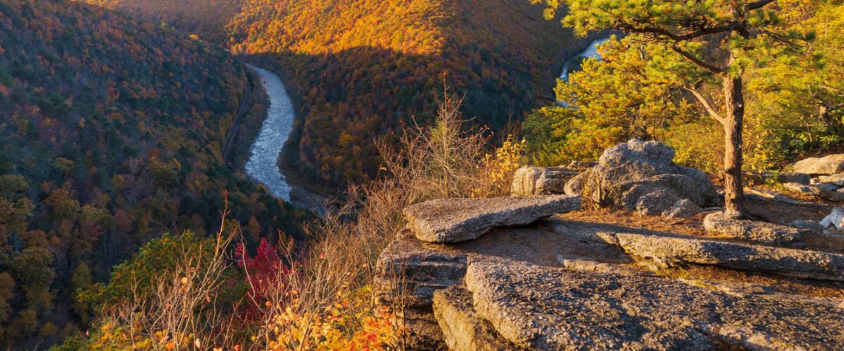 A river winding through a forested valley with autumn foliage.