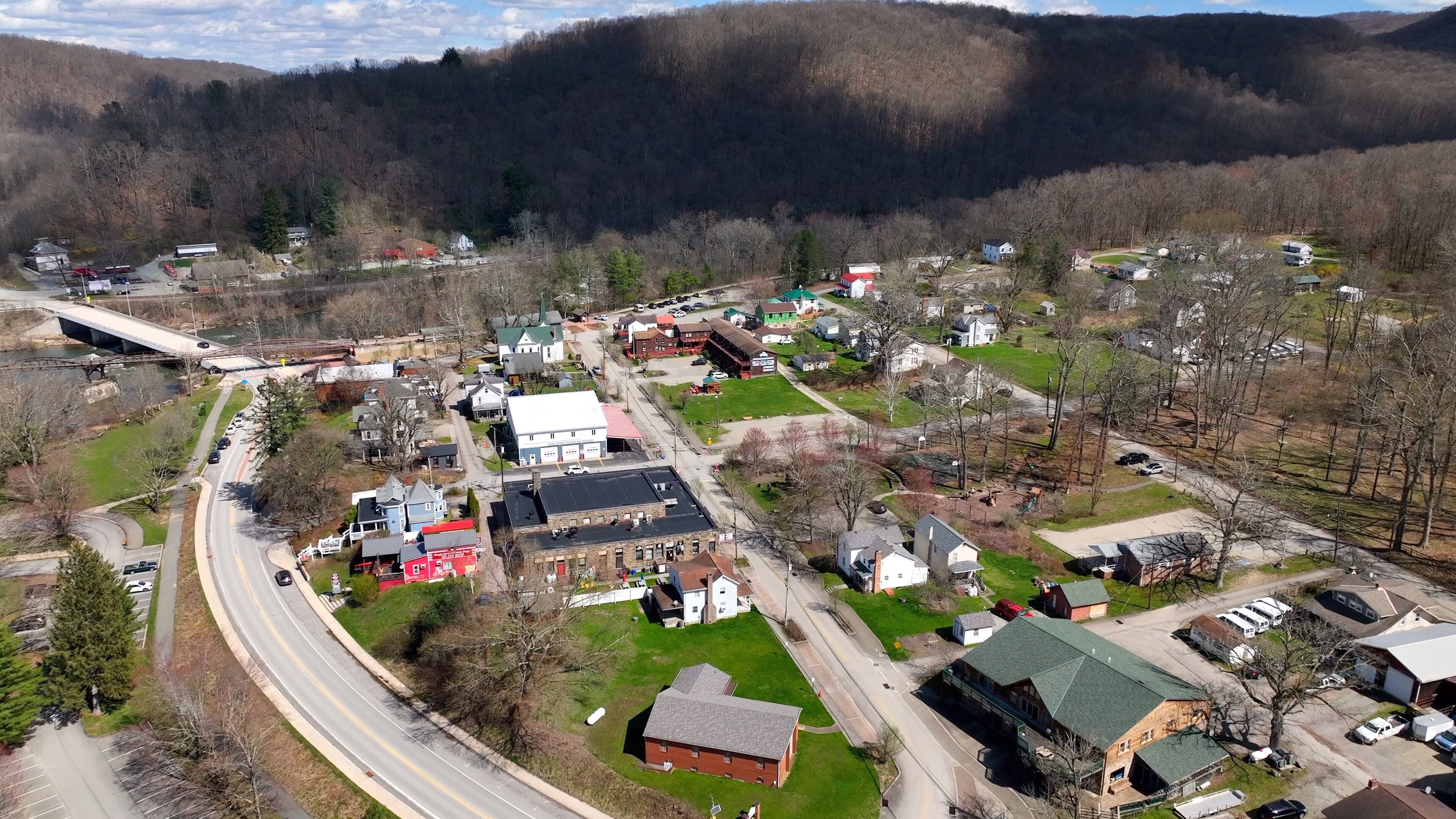 A small town with a river, a bridge, and a mountainous backdrop.