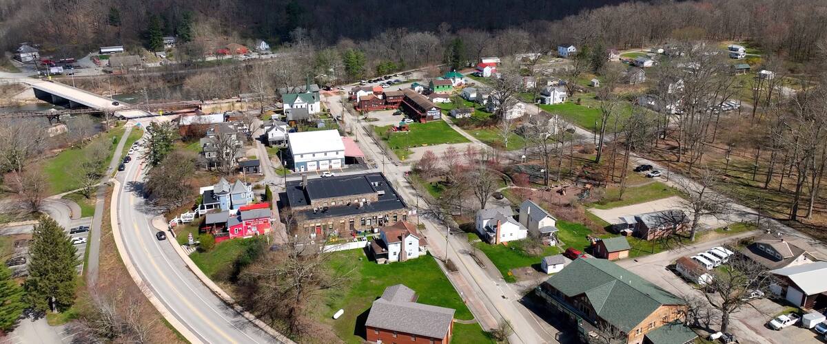 A small town with a river, a bridge, and a mountainous backdrop.