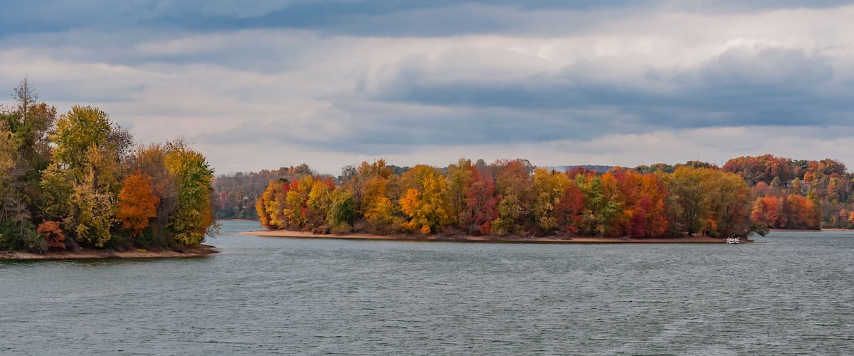 A lake surrounded by trees with autumn foliage.