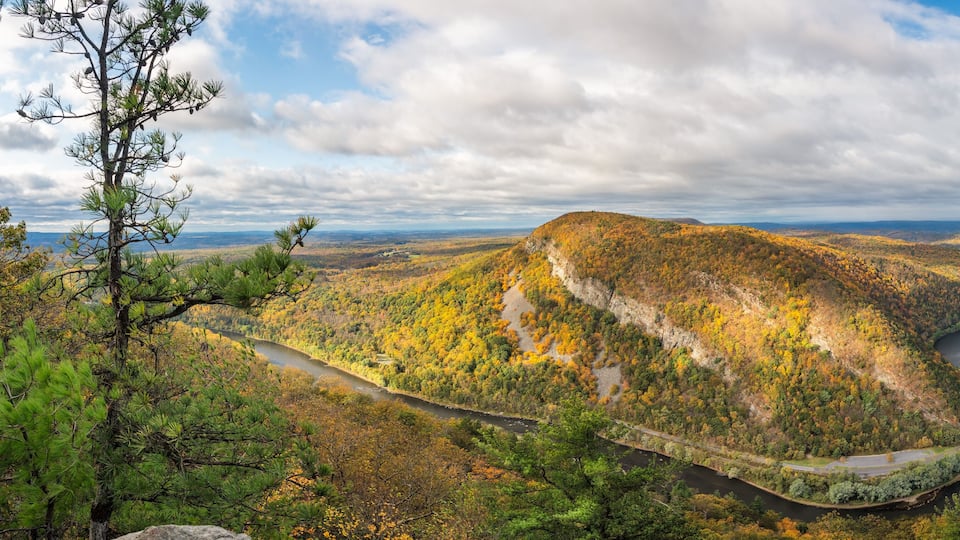 A winding river through a mountainous landscape with autumn foliage.