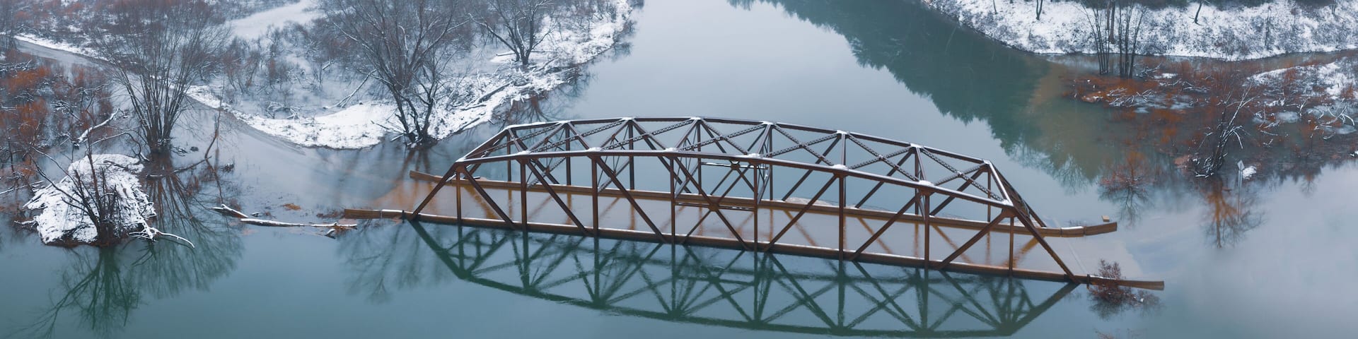 Flooded Bridge in Snowy Mountains from Above