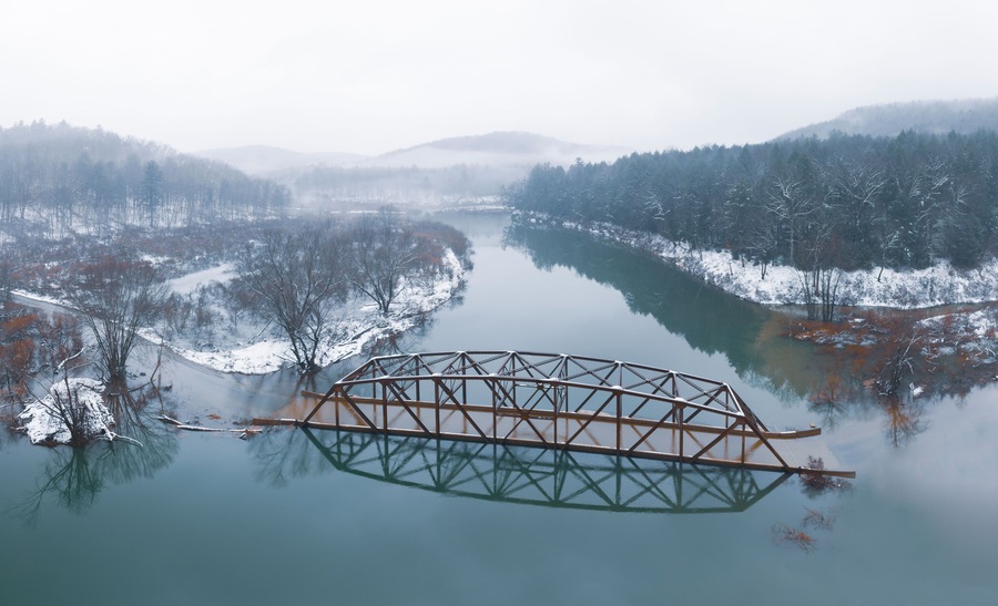 Flooded Bridge in Snowy Mountains from Above