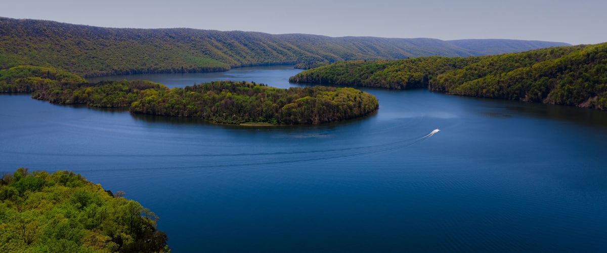 A river winding through a forested valley with several small islands.