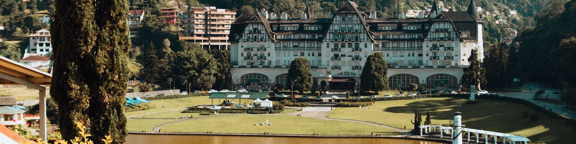 Landscape shot of the historic Quitandinha Palace with mountains and forests in the background
