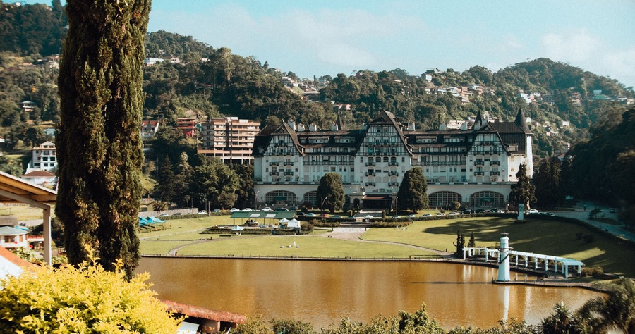 Landscape shot of the historic Quitandinha Palace with mountains and forests in the background