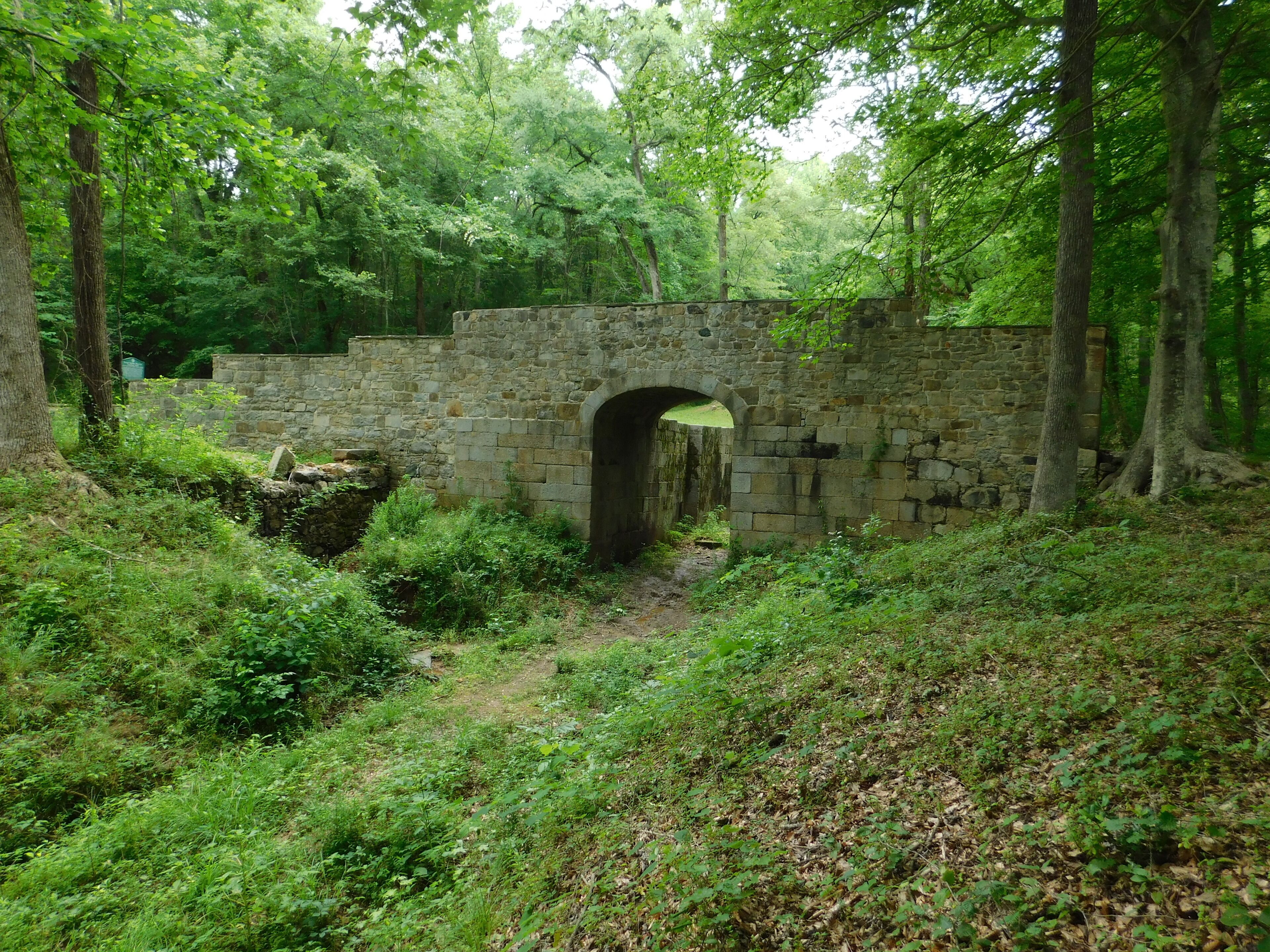 A stone bridge in a forested area.