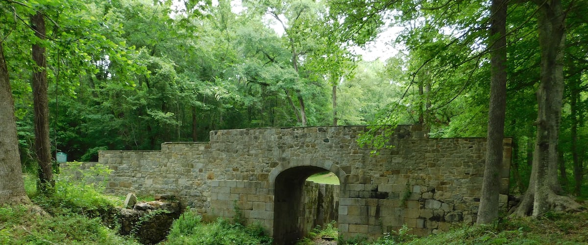 A stone bridge in a forested area.