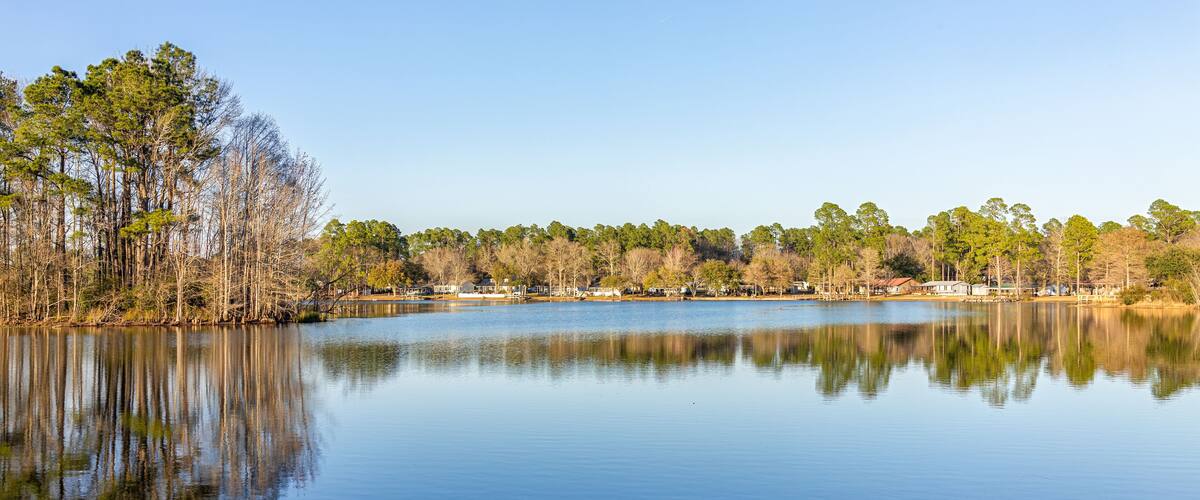 Eutawville, South Carolina sunset near Lake Marion with waterfront houses and docks water landscape view at Fountain lake in spring evening with nobody and pine trees