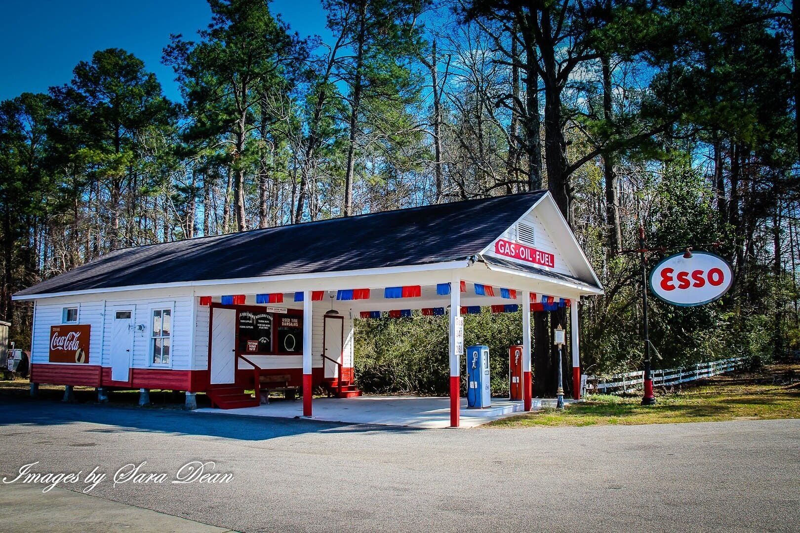 Esso Service Station, c.1922

The classic double bay service station porte-cochere design features a front gable roof with continuous return gable end with stone piers, lap siding, and has been rehabilitated with tin signs and antique pumps as a vintage gas station museum. A wide double window opens the view toward the store interior. The station has been moved from its original site. 