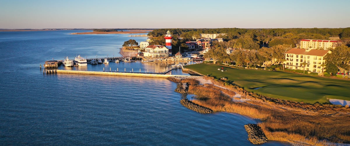 Un pueblo costero con un faro, un puerto deportivo y un campo de golf.