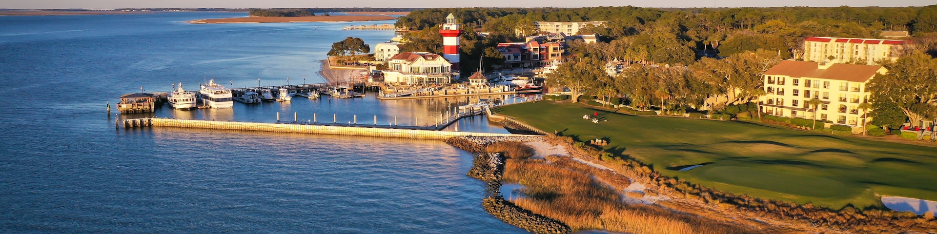 Eine Küstenstadt mit Leuchtturm, Hafen und Golfplatz.
