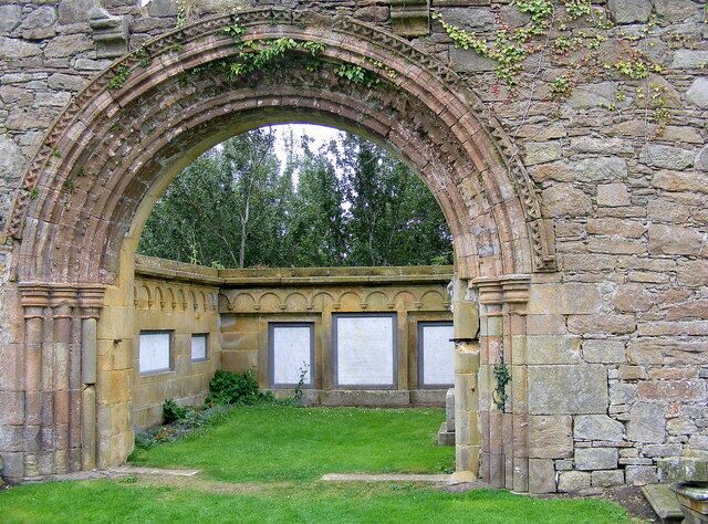 A Norman arch at Kinloss Abbey, Moray, Scotland. The marble slabs through the arch are in memory of the various members of the Dunbar family.