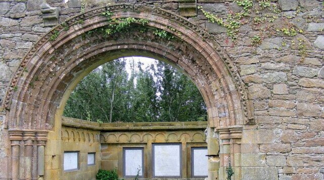 A Norman arch at Kinloss Abbey, Moray, Scotland. The marble slabs through the arch are in memory of the various members of the Dunbar family.