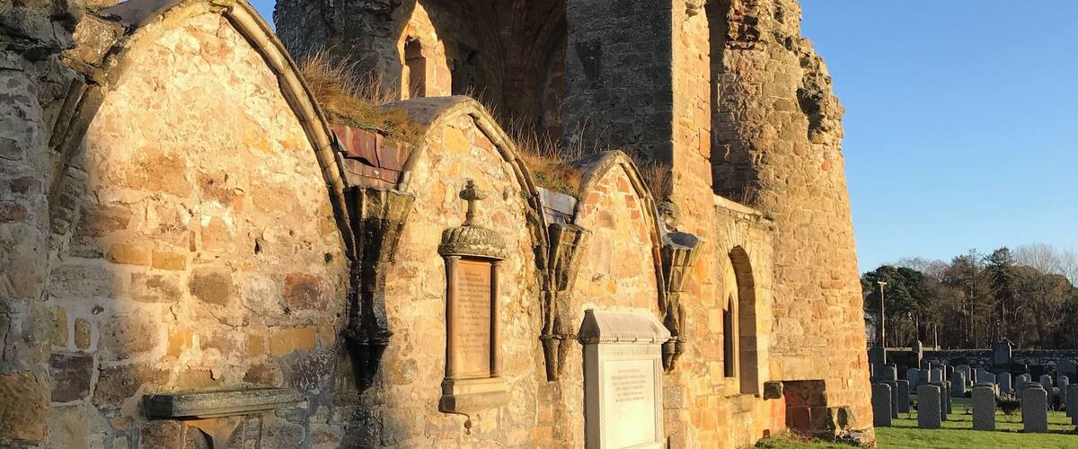 An old stone building with arched windows and a large central archway.
