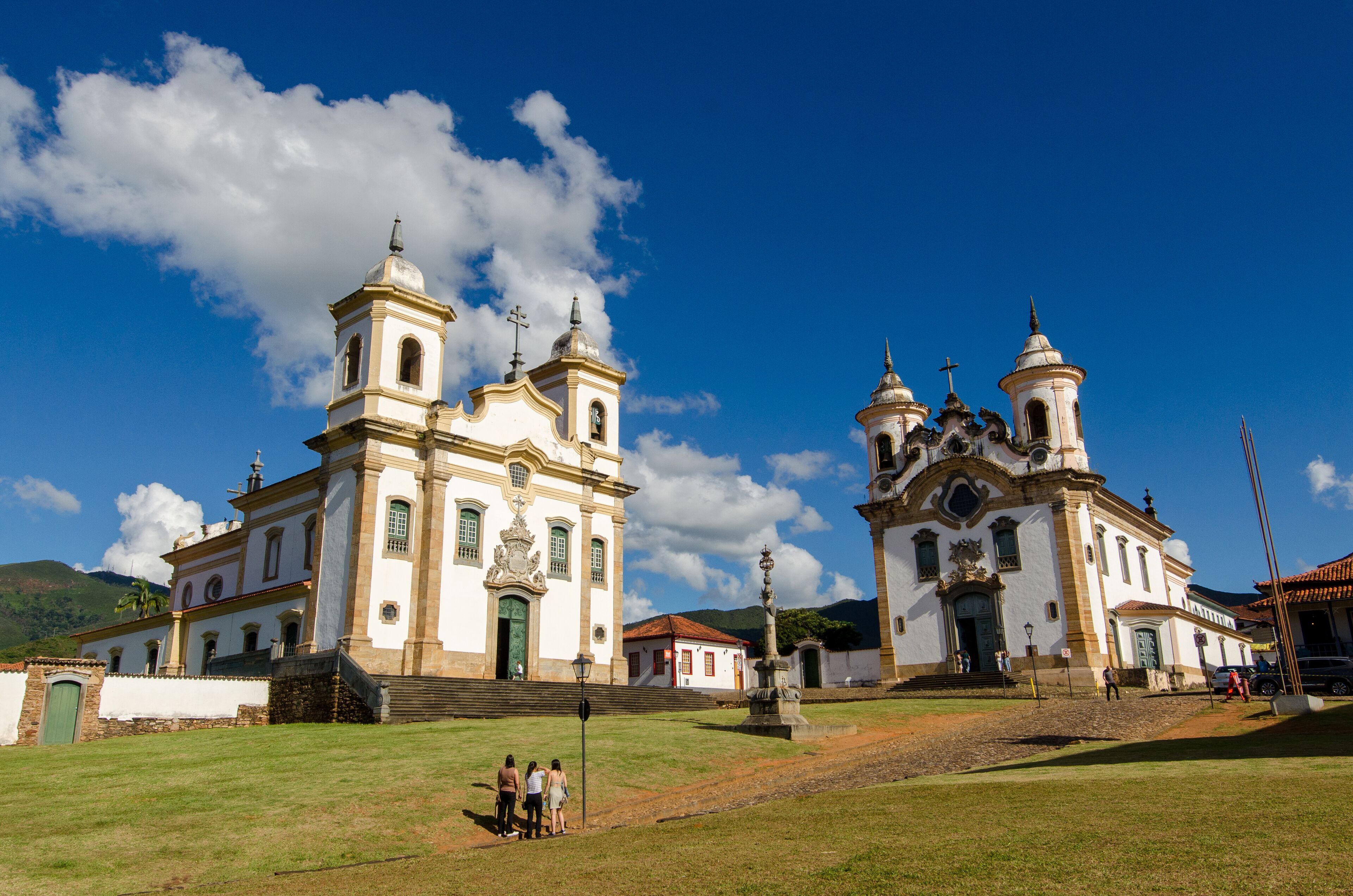 A historic church with two bell towers and a statue in front.