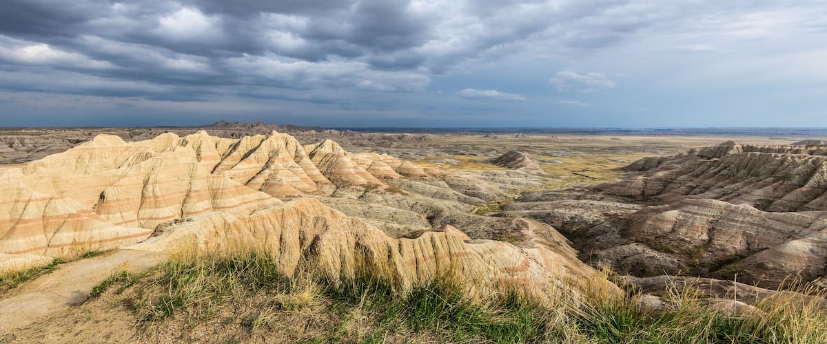 A rugged landscape with layered rock formations and a cloudy sky.