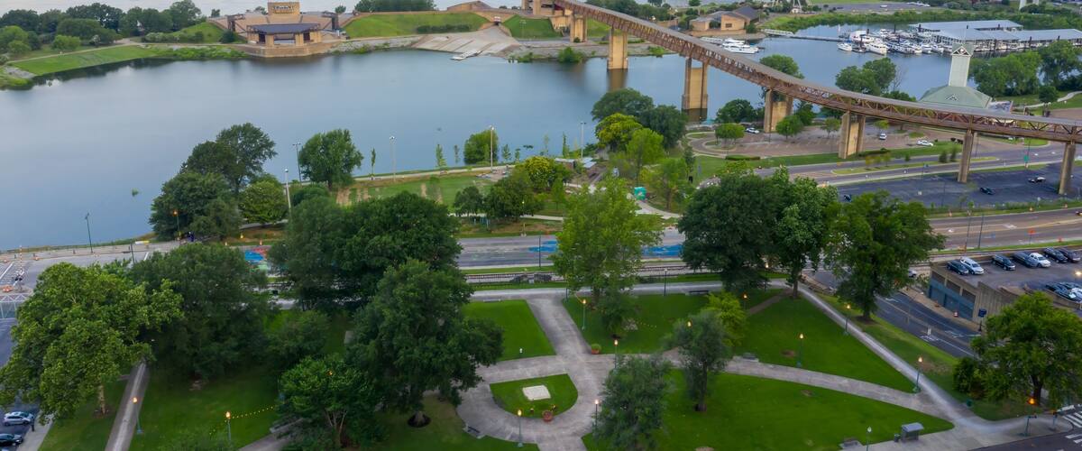 A river with a bridge, a park, and a historic building.