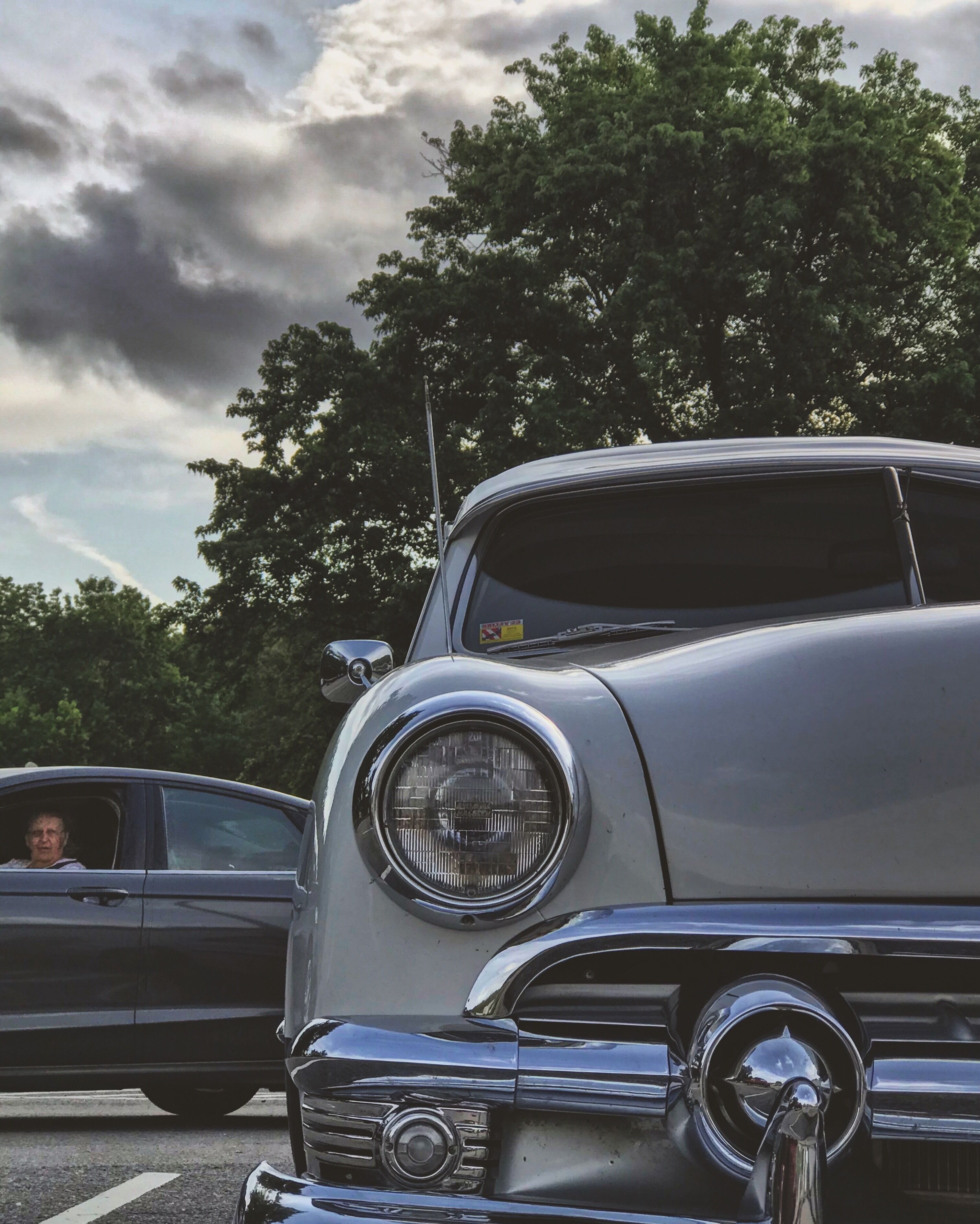 A vintage car with a round headlight and chrome details.