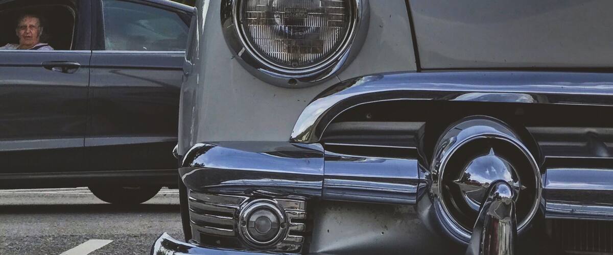 A vintage car with a round headlight and chrome details.