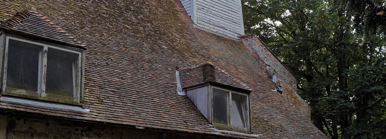 The weatherboard and shingle tower and broach spire, buttressed nave north wall, and table tomb from the north of the churchyard of All Saints Church, West Stourmouth, in the civil parish of Stourmouth in Kent, England. Camera: Canon EOS 6D with Canon EF 24-105mm F4L IS USM lens. Software: RAW file lens-corrected, optimized, perhaps cropped, and converted to JPEG with DxO OpticsPro 11 Elite, and likely further optimized with Adobe Photoshop CS2.