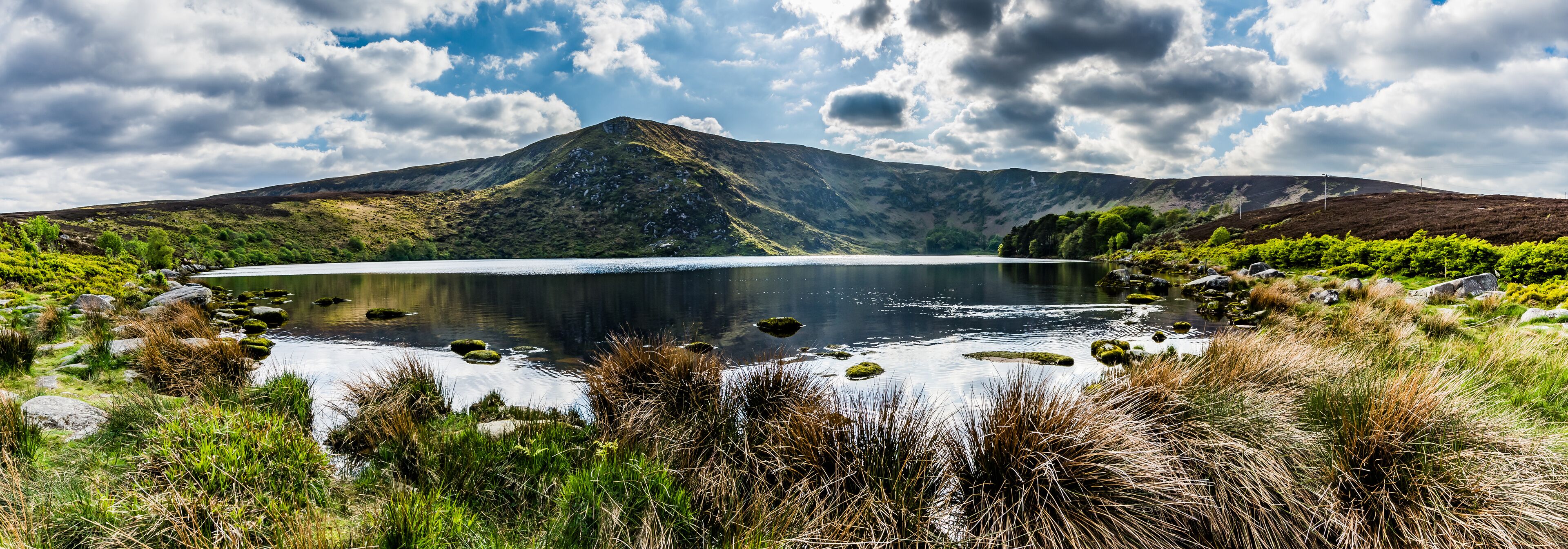 A lake surrounded by mountains and lush greenery.