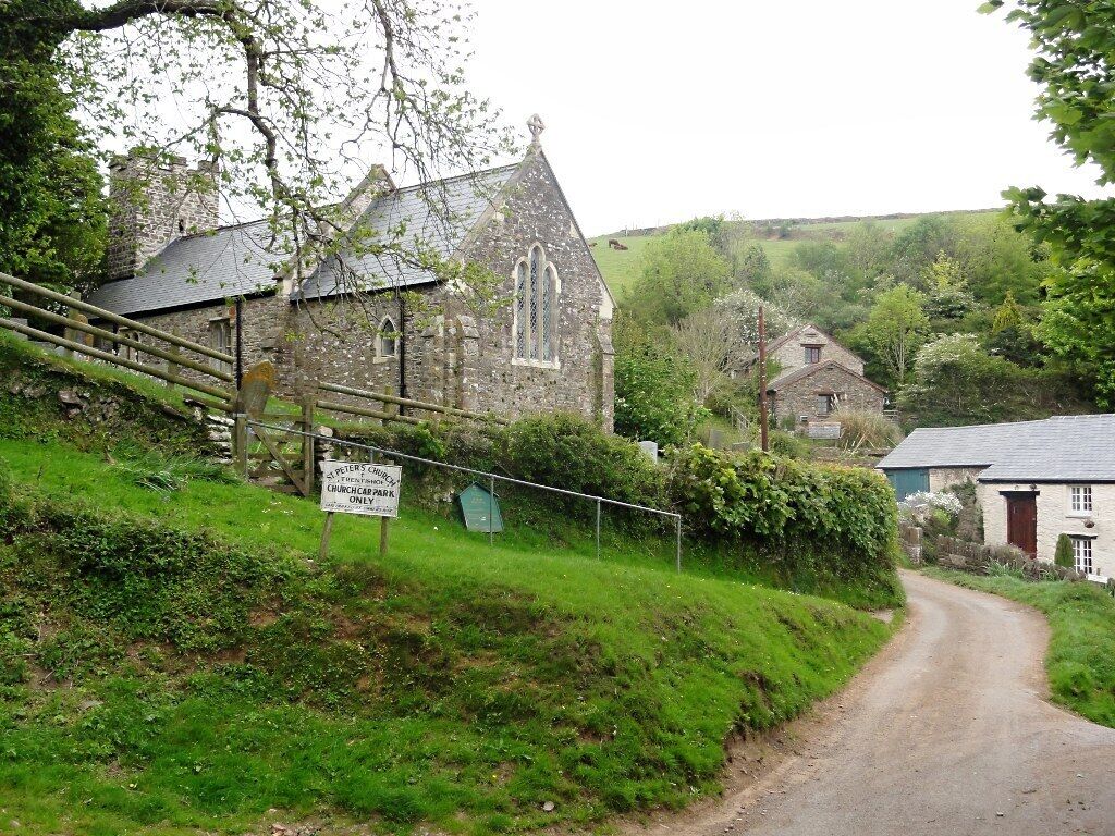 A rural road leading to a stone church with a sign indicating it is the church of St. Peter's Church, Churchcap Park, only.