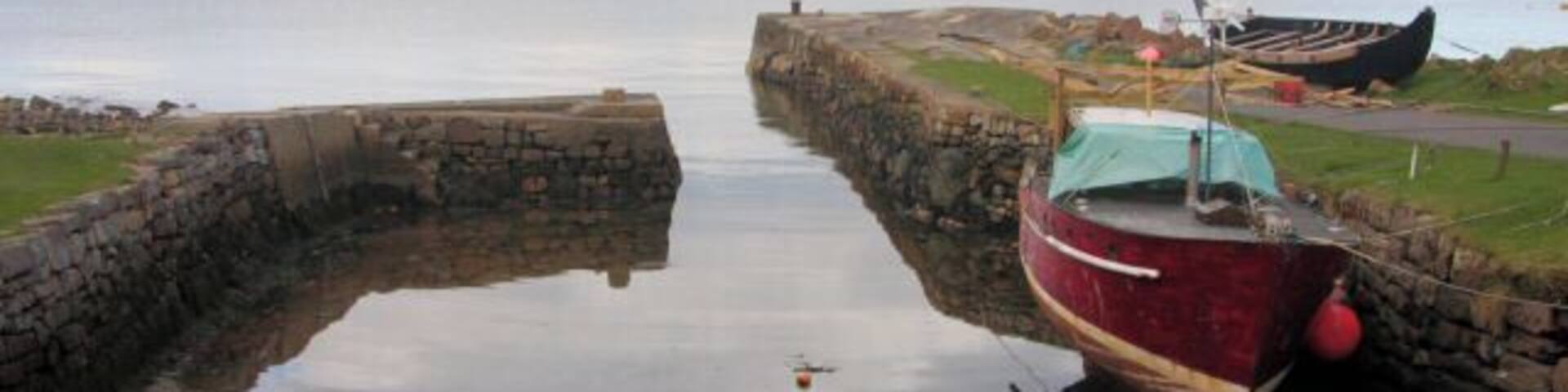 Corrie Harbour, Isle of Arran On a short stretch of Arran coastline of less than three kilometres, there are no less than three man-made harbours or jetties, as well as a fourth natural harbour. From the north, they are: Sannox Jetty, Corrie Harbour (otherwise known as 'The Port'), Ferry Rock (the natural harbour) and the Sandstone Jetty. This tiny harbour is 'The Port', which dries at low water. Due to its very narrow entrance, only small leisure craft can enter the enclosed harbour.