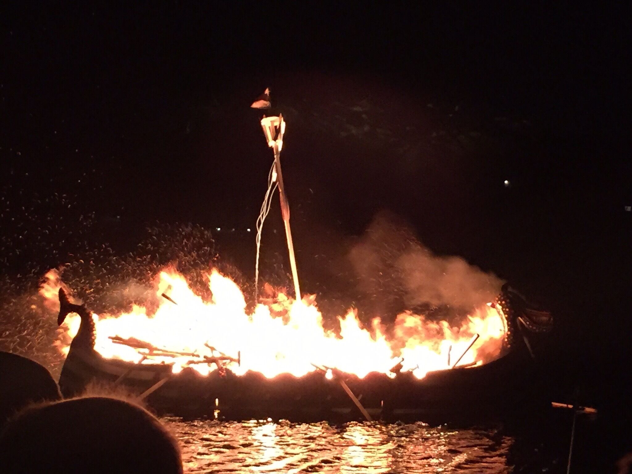 A boat on fire with flames and smoke.