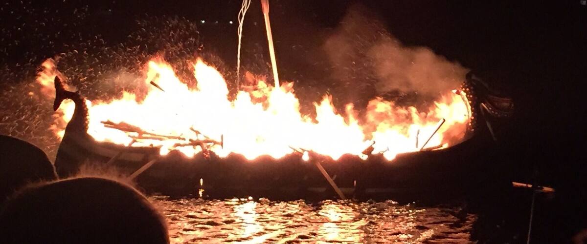 A boat on fire with flames and smoke.