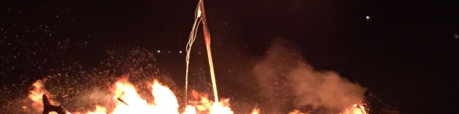 A boat on fire with flames and smoke.