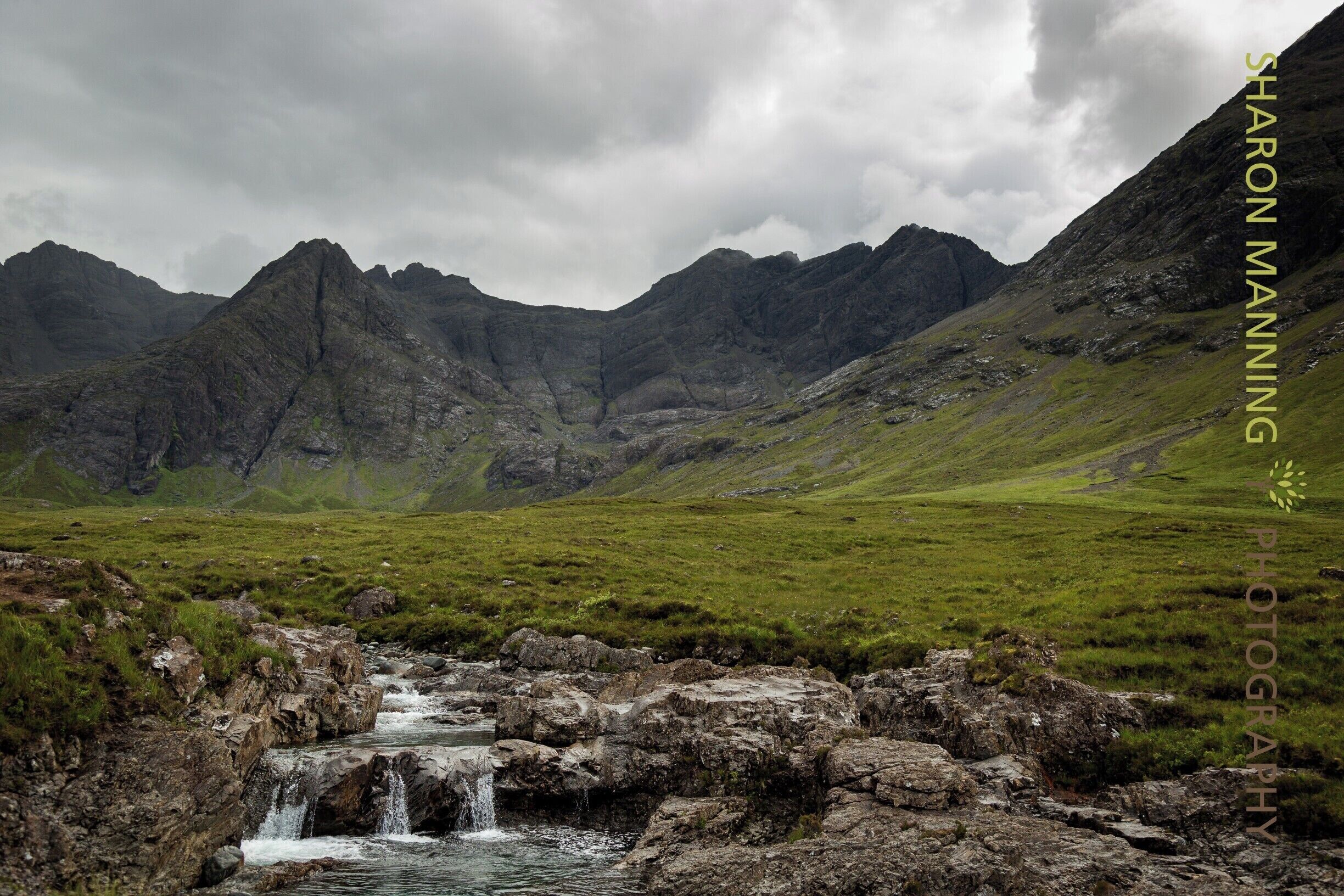 A mountainous landscape with a waterfall flowing over rocks.