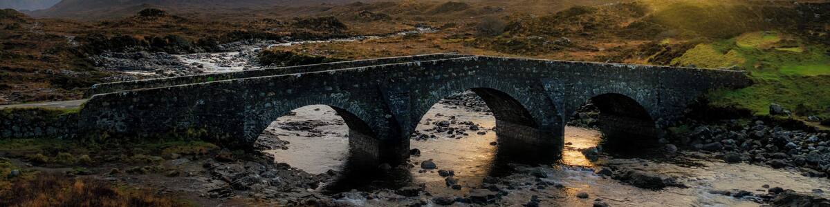 The Isle of Skye has always been seen as a magical place. Along with the beautiful landscape there are plenty of myths and legends to stimulate your imagination. With the landscape it’s easy to believe these stories. The Sligachan Bridge has a great tale, and what’s more you can gain eternal beauty from the waters below the bridge.
This photo was photographed from the new bridge with a view of the Cuillins Mountains at the back.