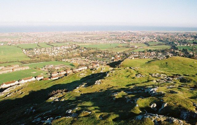 A hilly landscape with a town nestled in the valley.