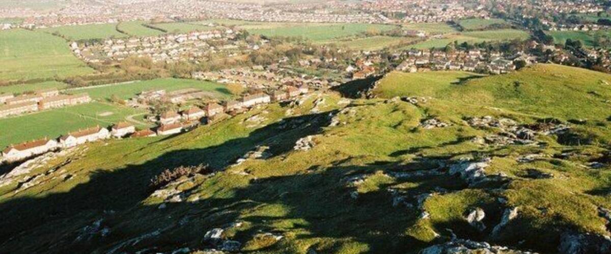 A hilly landscape with a town nestled in the valley.