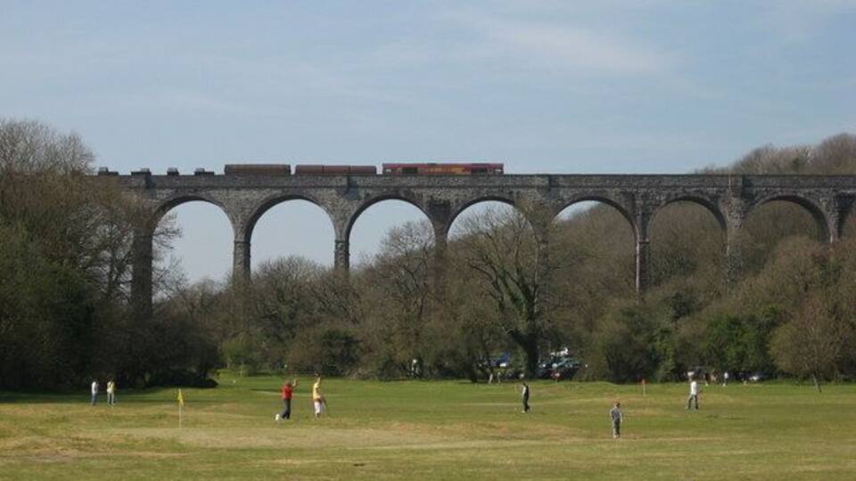 Porthkerry Viaduct Golfers play undisturbed by a steel train heading east over Porthkerry Viaduct.