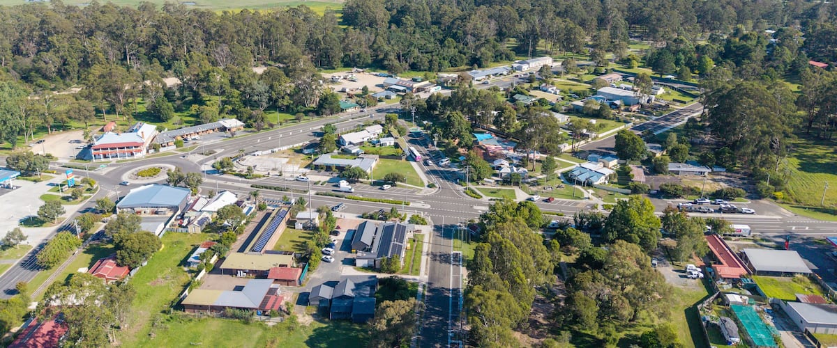 An aerial view of a small town surrounded by hills and forests.