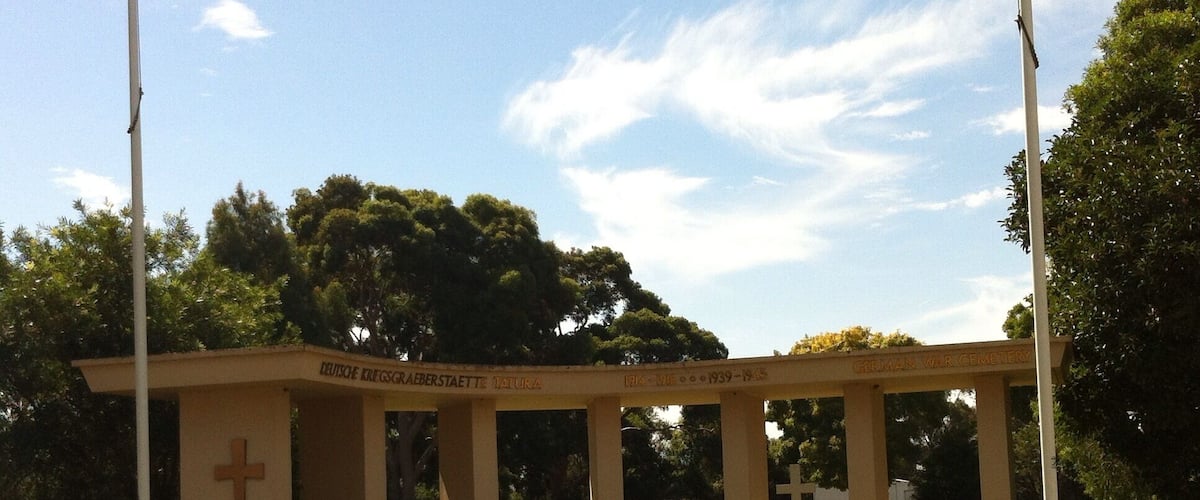 A memorial with a cross, a plaque, and a fence.