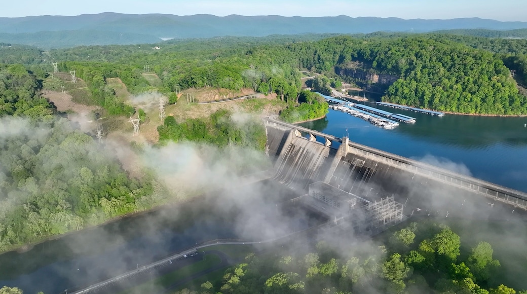 Norris Dam in Tennessee mountains at early morning sunlight beneath misty fog and clouds at daybreak