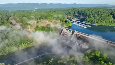 Norris Dam in Tennessee mountains at early morning sunlight beneath misty fog and clouds at daybreak