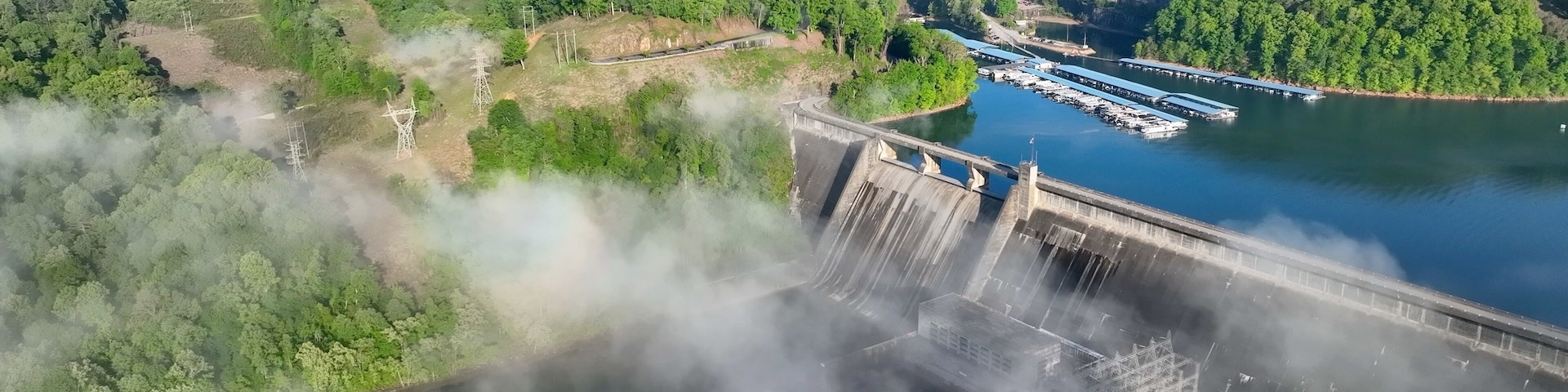 Norris Dam in Tennessee mountains at early morning sunlight beneath misty fog and clouds at daybreak