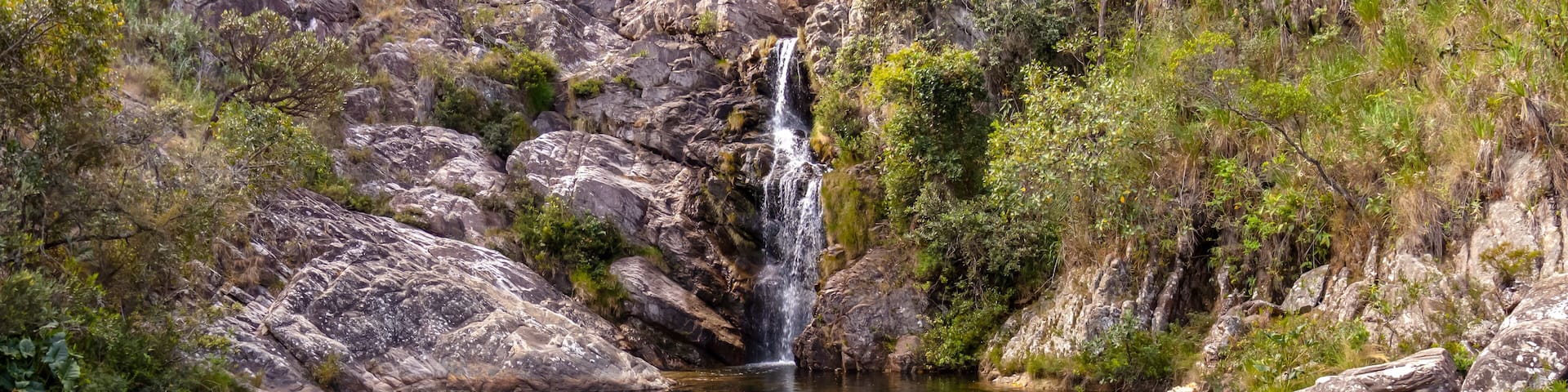Gavião waterfall surrounded by rocks with natural pool, Serra do Cipo National Park, Minas Gerais, Brazil