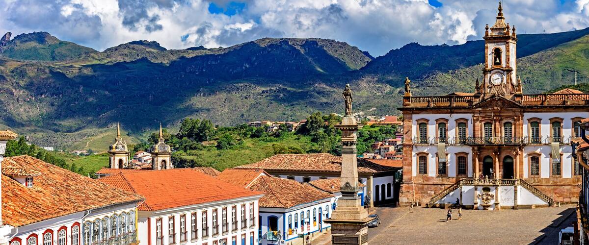 A historic town with a prominent church, a clock tower, and a statue.