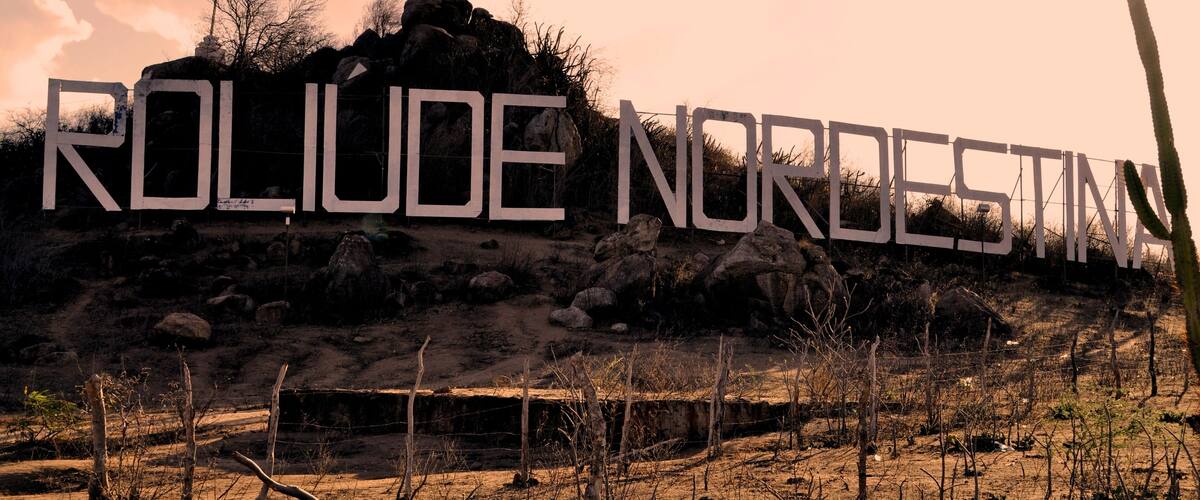 A large sign with the text 'ROLIDE NORDSTINA' on a rocky hill with sparse vegetation.