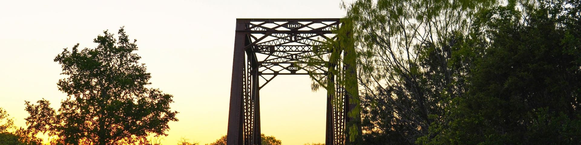 Railroad track bridge lined with bluebonnets in Texas Hill Country