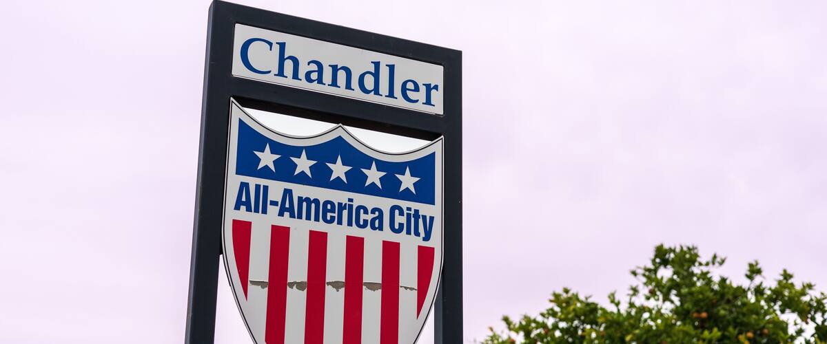 A sign with 'Chandler' and 'All-America City' along with a shield featuring stars and stripes.