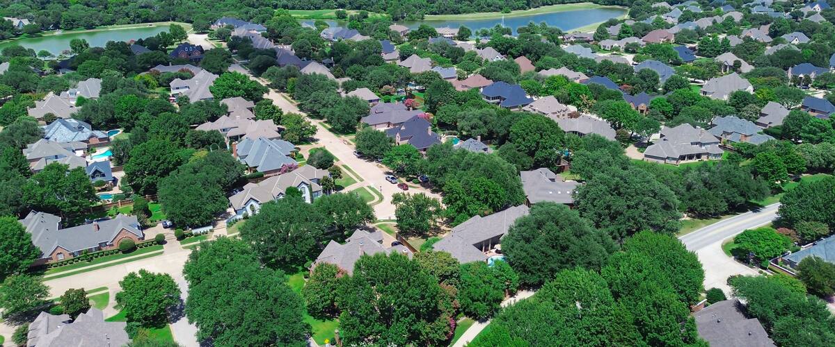 Dual scenic ponds with water fountain in upscale neighborhood in Colleyville, Texas, dense residential layout with tree-lined streets, landscaped yards, and large two-story homes, suburbs Dallas