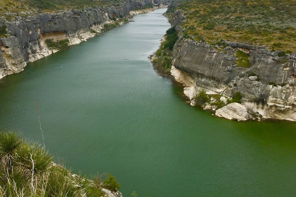A river winding through a rocky canyon with sparse vegetation.