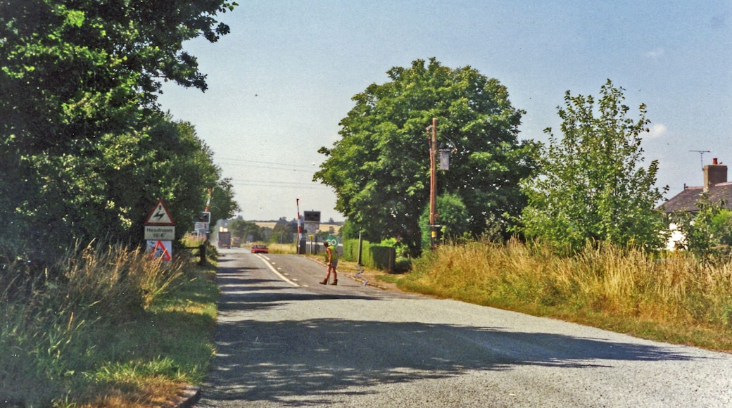 Approaching crossing at site of Hixon station, 1995 View westward, the station (unstaffed Halt since 20/7/31, closed 6/1/47 when local services ceased) had been on the left: ex-North Stafford Stone (to right) - Colwich (to left) loop used by London Euston - Manchester through trains running via Stoke-on-Trent and electrified in 1965-66. There was an RAF Airfield close by and the line was frequently blocked by crashing aircraft during World War Two, but the site is famous for the extraordinary accident of 6/1/68 when an express crashed into a low-loader creeping across the level-crossing carrying a 120-ton electrical transformer.